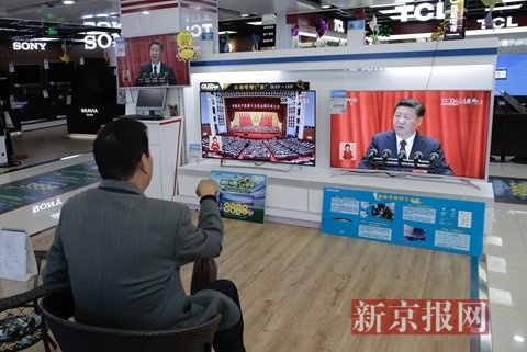 北京北三环中路一家电器城里，顾客在电视机前收看开幕式直播。