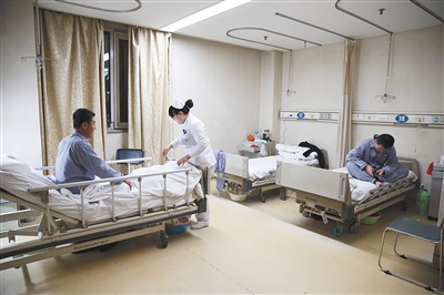 肝胆外科病房,护士帮病人整理床铺.